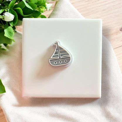 Close-up of the sailboat polymer clay mold with a lavender clay cutout, highlighting its sharp, clean edges.