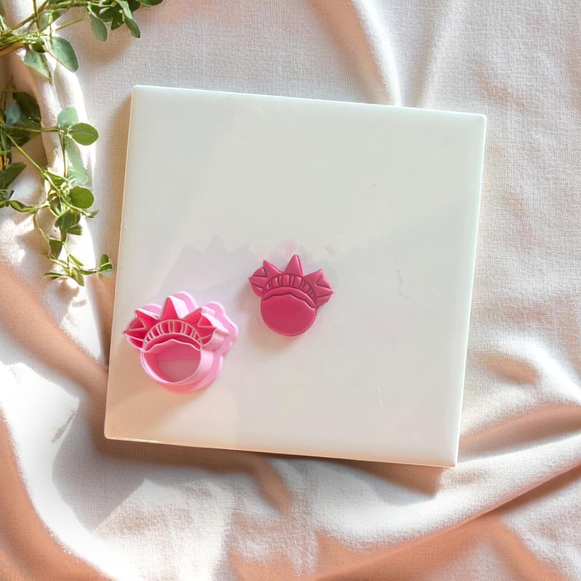 Liberty Crown cutter next to clay cutouts in red, perfect for USA-inspired dangles