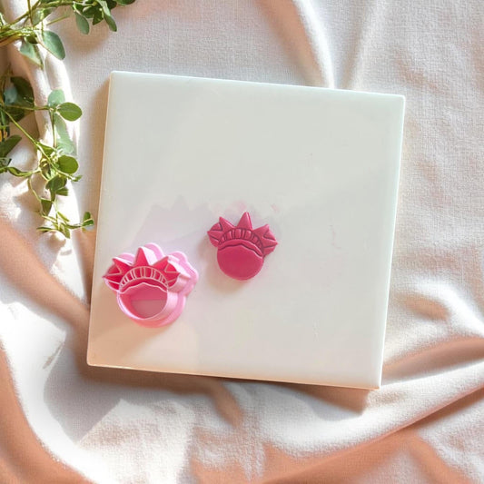 Liberty Crown cutter next to clay cutouts in red, perfect for USA-inspired dangles