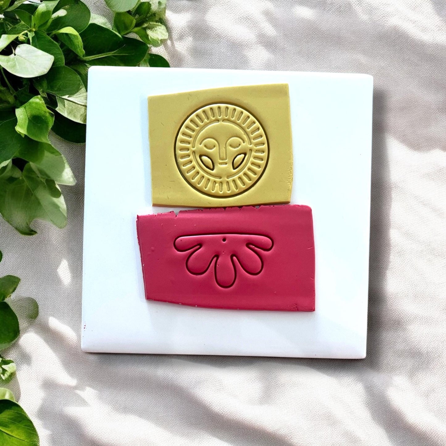 Yellow clay slab stamped with a radiant sun face cutter design