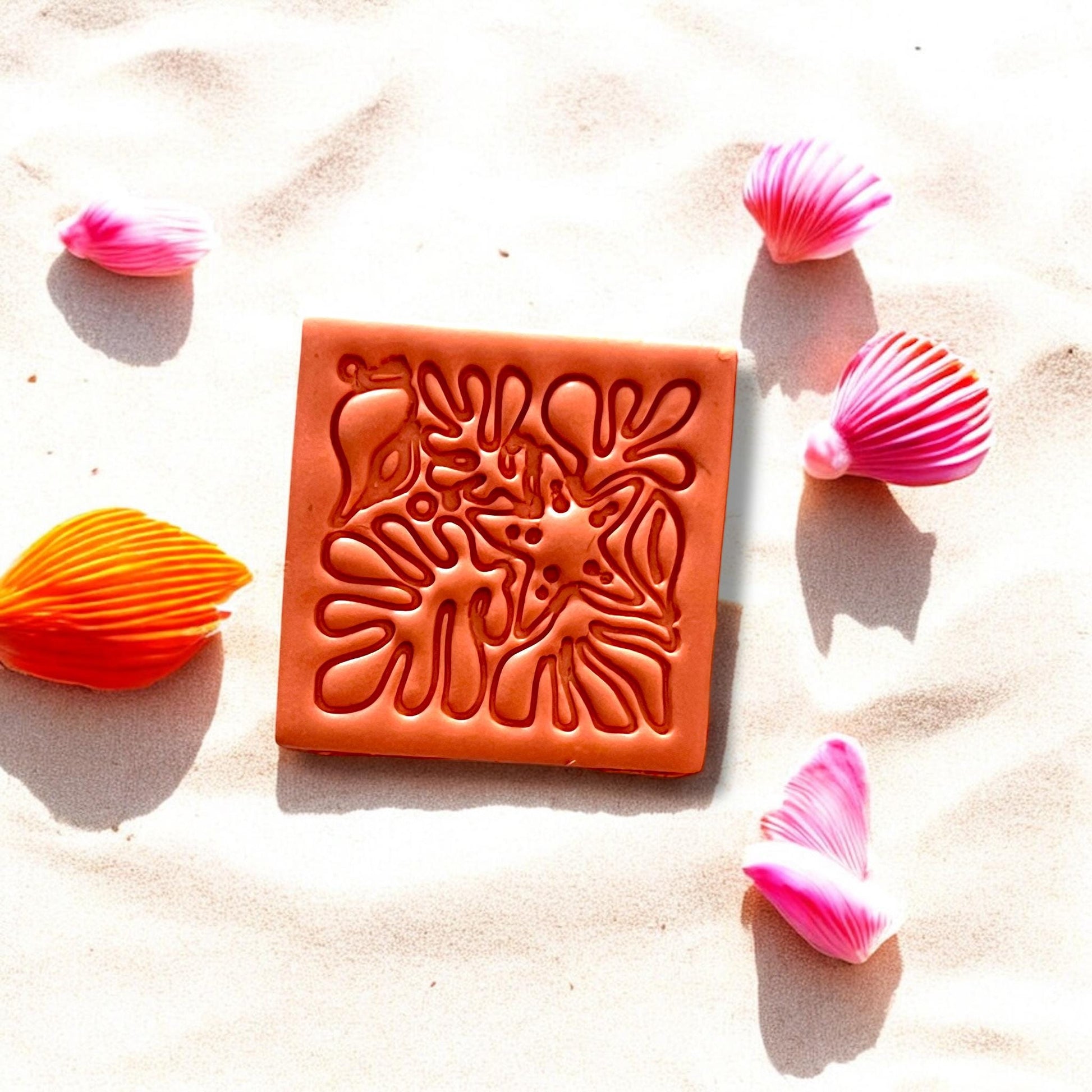 Close-up of starfish and coral beach motif slab on sand
