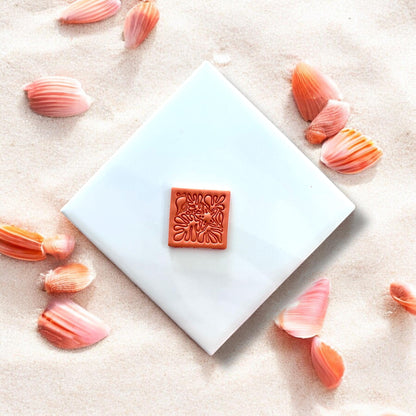 Finished square clay piece with beachy coral shell design