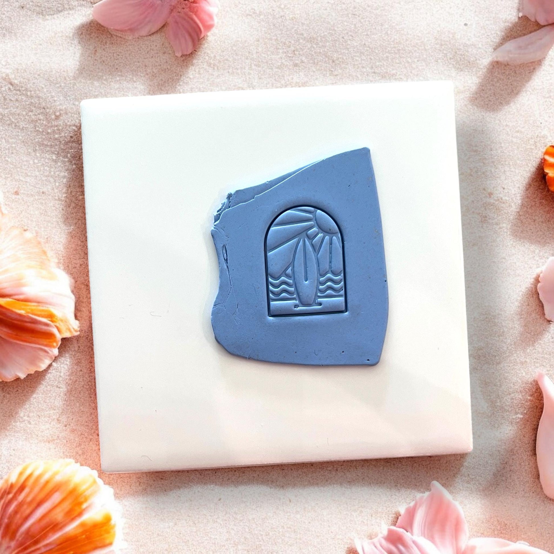 Blue clay slab with surfboard and sunset arch impression