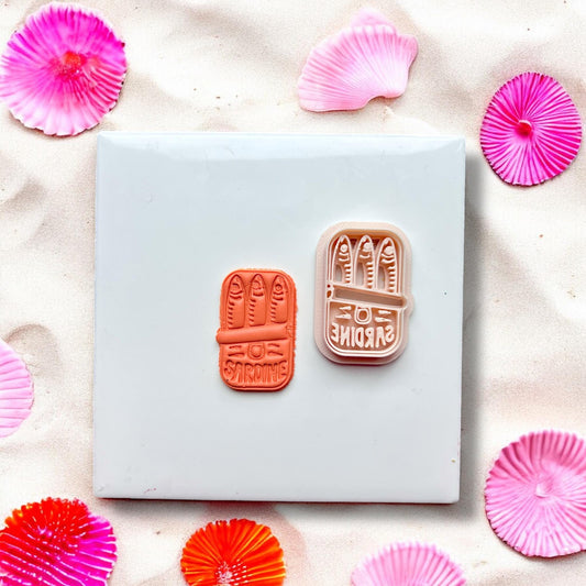 Sardine can clay cutter and finished clay piece side by side