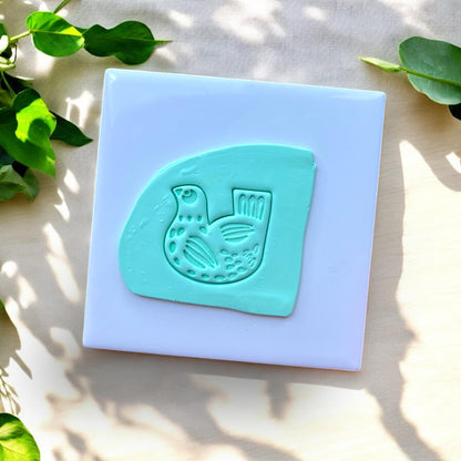 clay slab with folk art bird impression