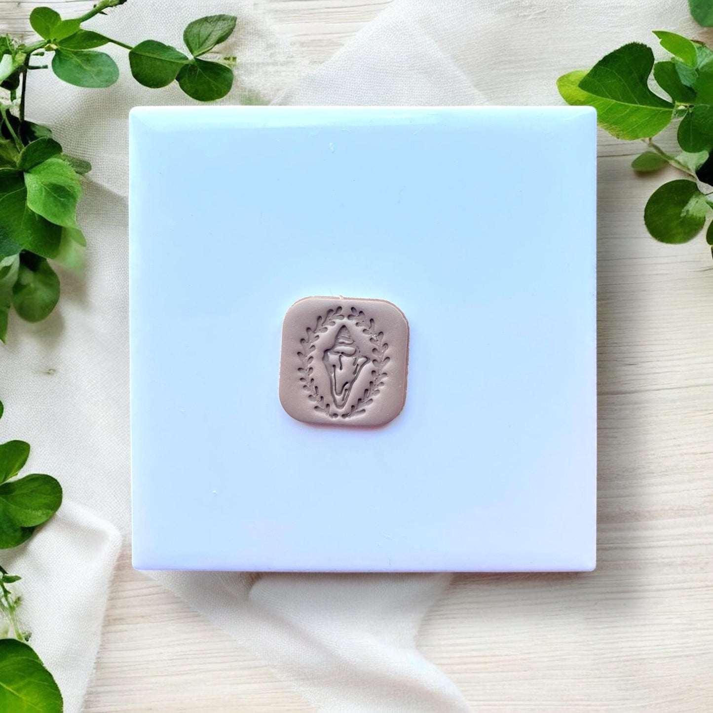finished conch shell clay charm on white tile