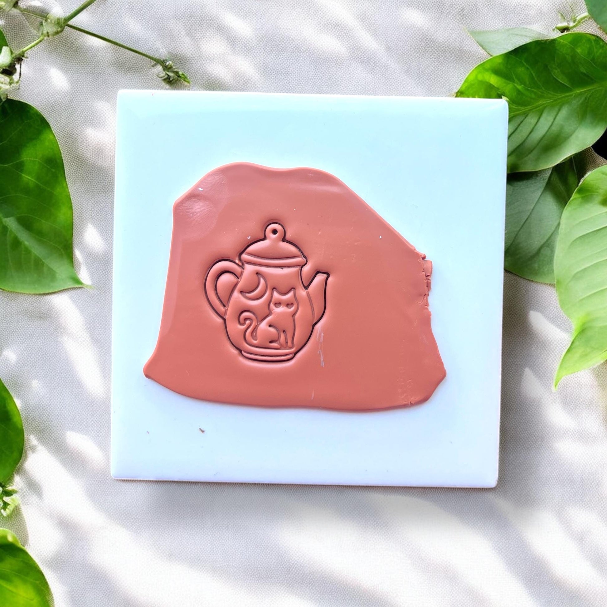 brown clay slab with cat teapot impression