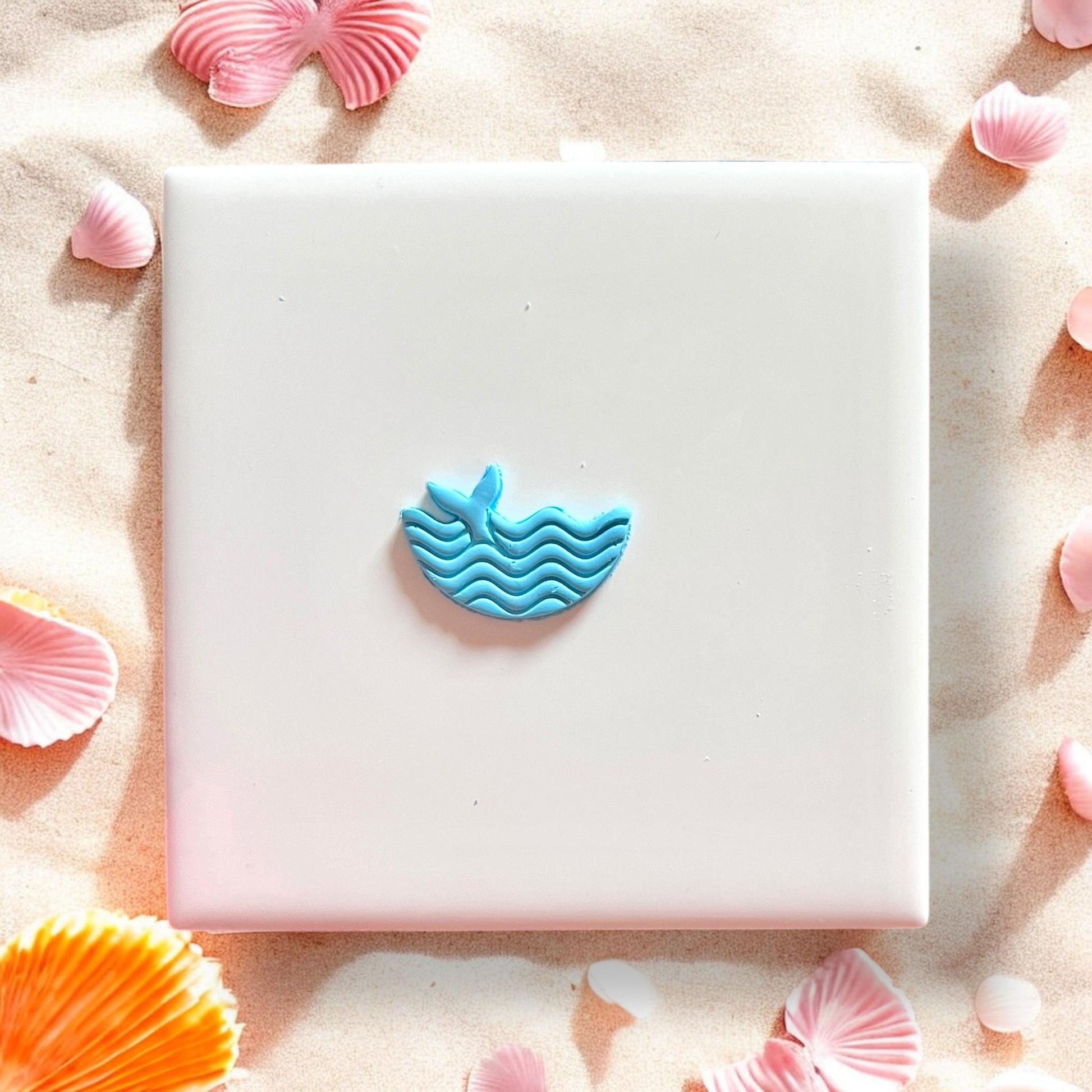 Finished blue clay piece with whale tail and ocean waves