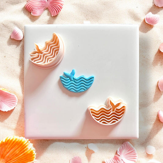 Whale cutter set with completed clay piece on beach background