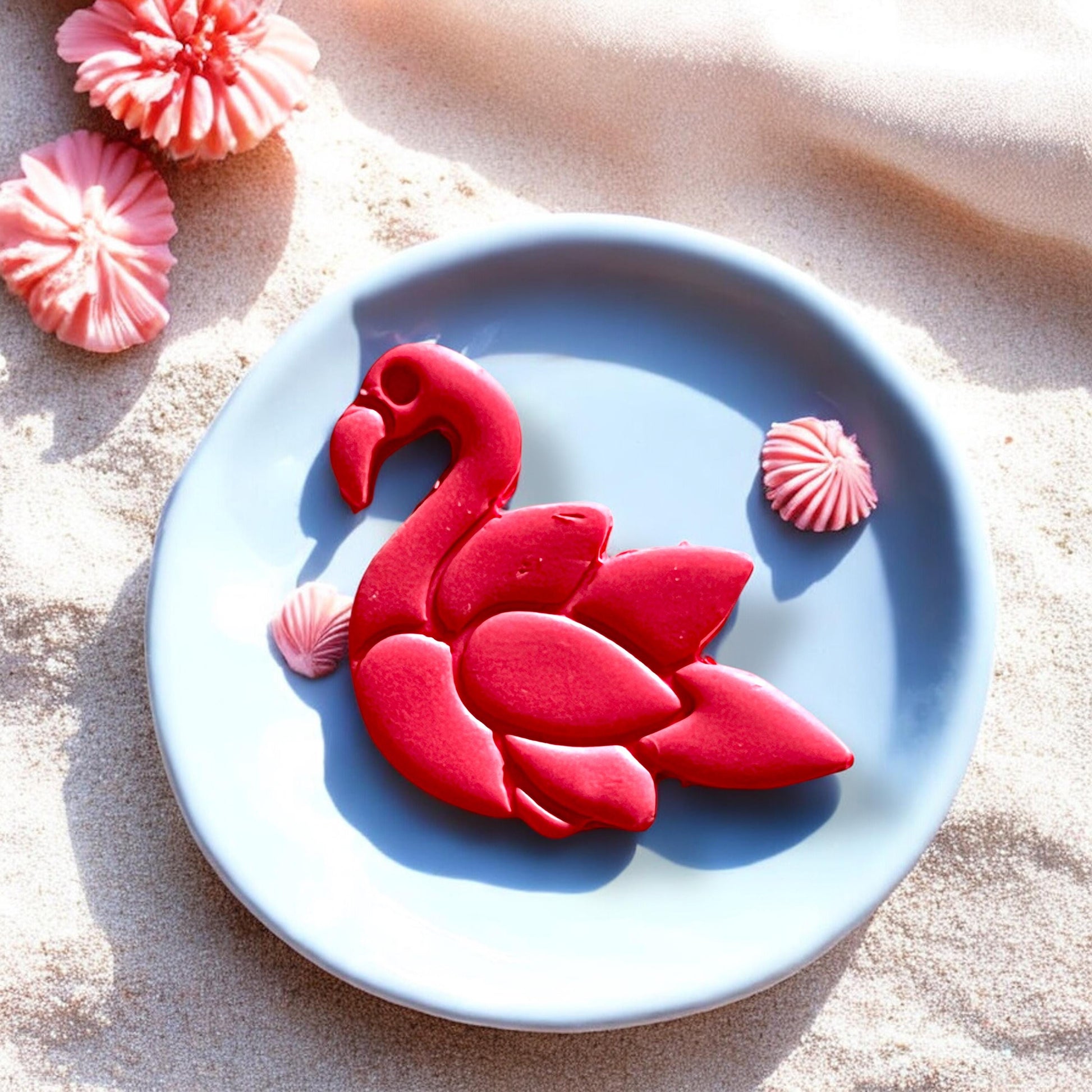 Flamingo earring cutter and clay cutout styled on sand and shells