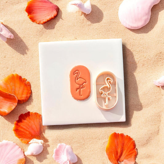 Flamingo clay shape and matching cutter shown side-by-side on a white tile, seashells scattered around