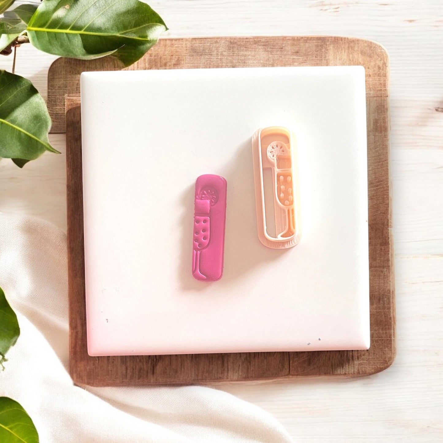 Cutter next to matching clay design on a square tile