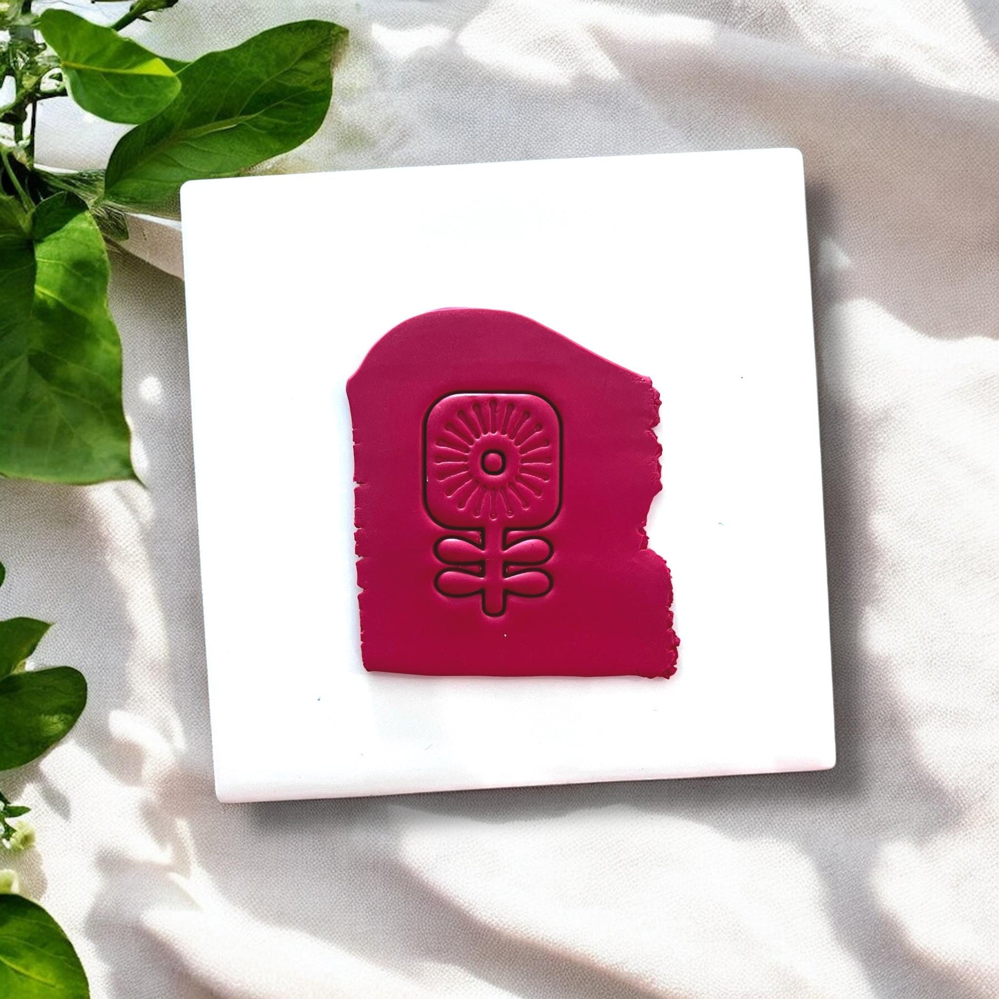 Red clay slab with scandi flower shape embossed on white tile