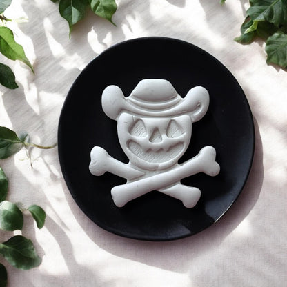 Halloween cowboy skull clay piece on black plate with greenery