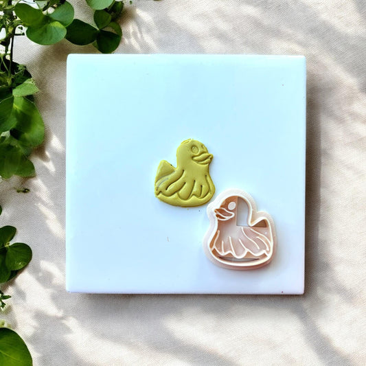 Duck floatie cutter next to clay impression