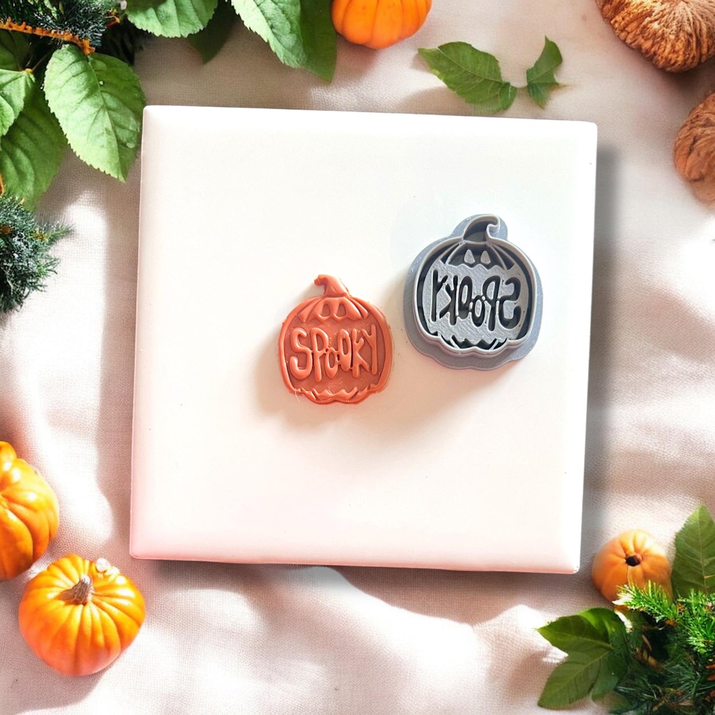 Spooky pumpkin clay shape next to cutter