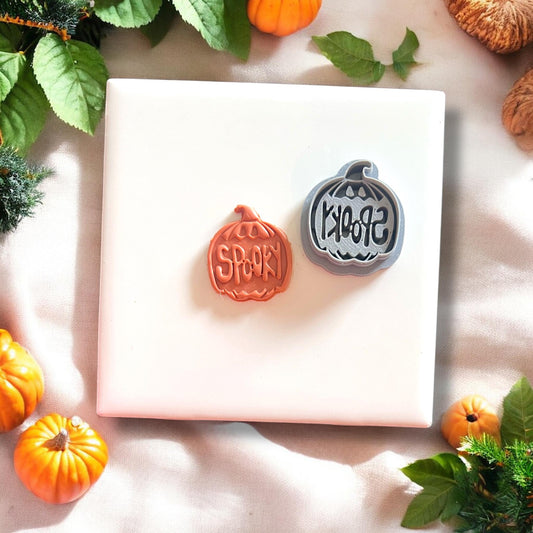 Spooky pumpkin clay shape next to cutter
