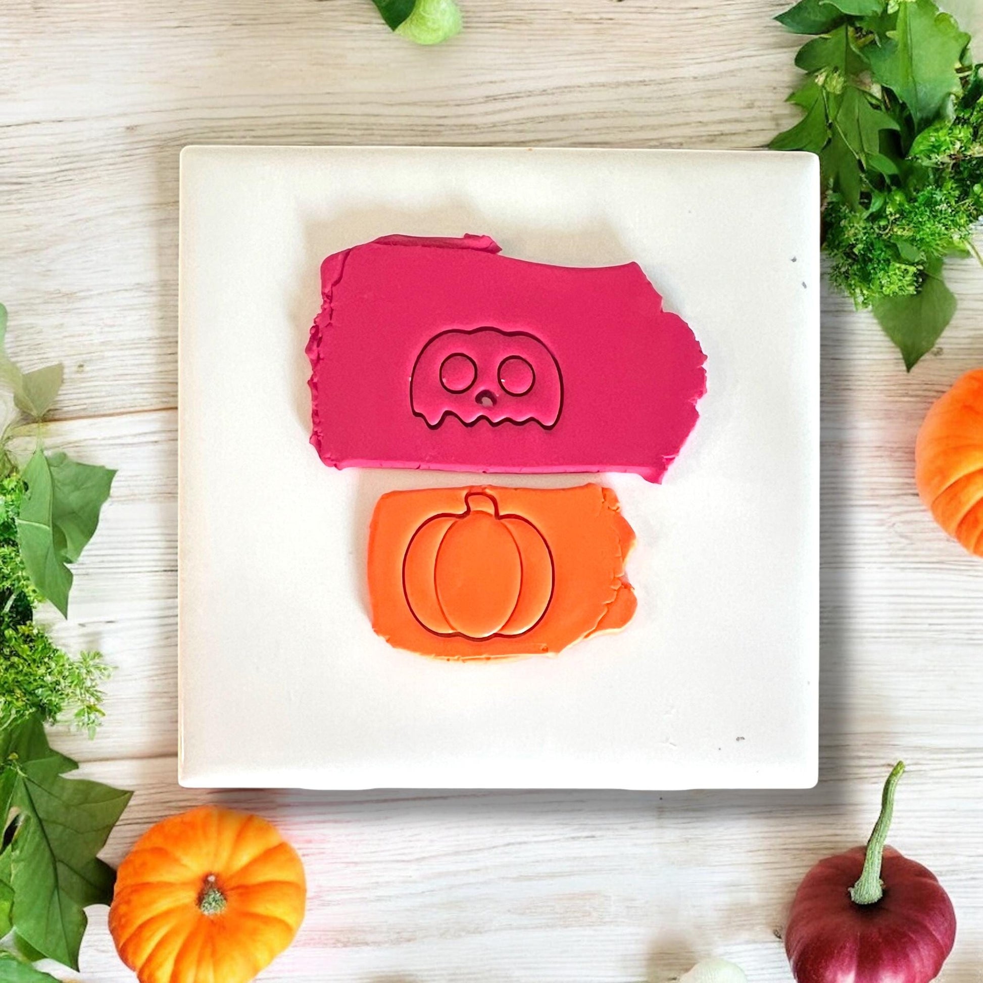 Drippy skull face cutter and pumpkin cutter pressed into clay