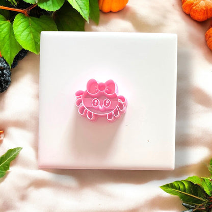 Pink girly spider polymer clay cutter on white tile