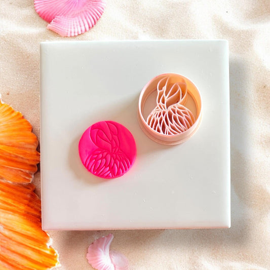 Cutter beside pink clay flamingo impression on white tile