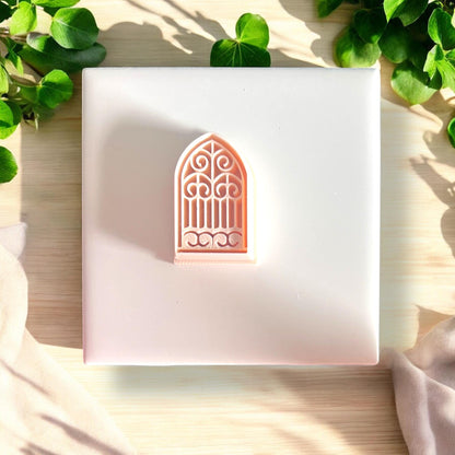 pink arched cutter on white tile with leaves