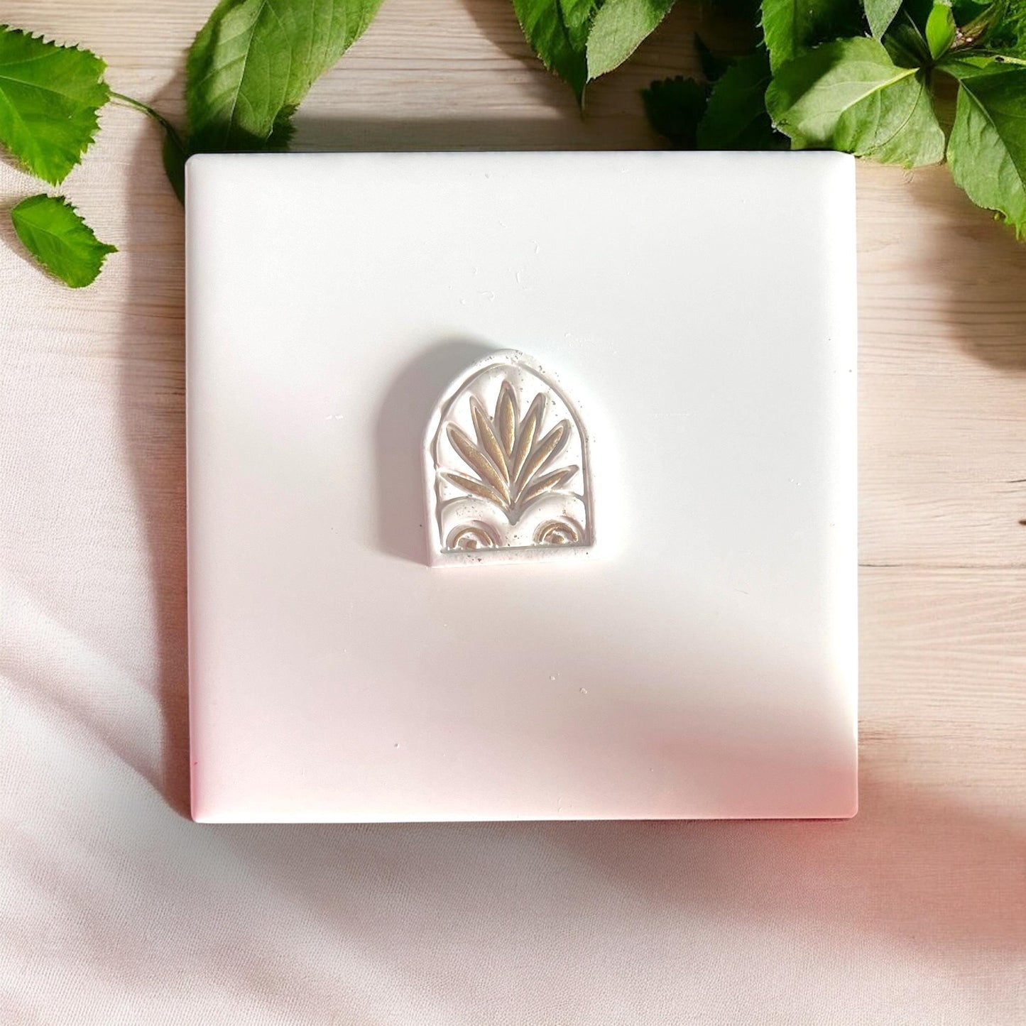 Palm Scroll Window cutter on tile surrounded by greenery
