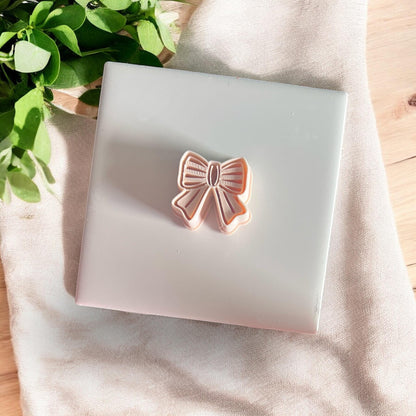 angled shot of bow clay cutter on white tile