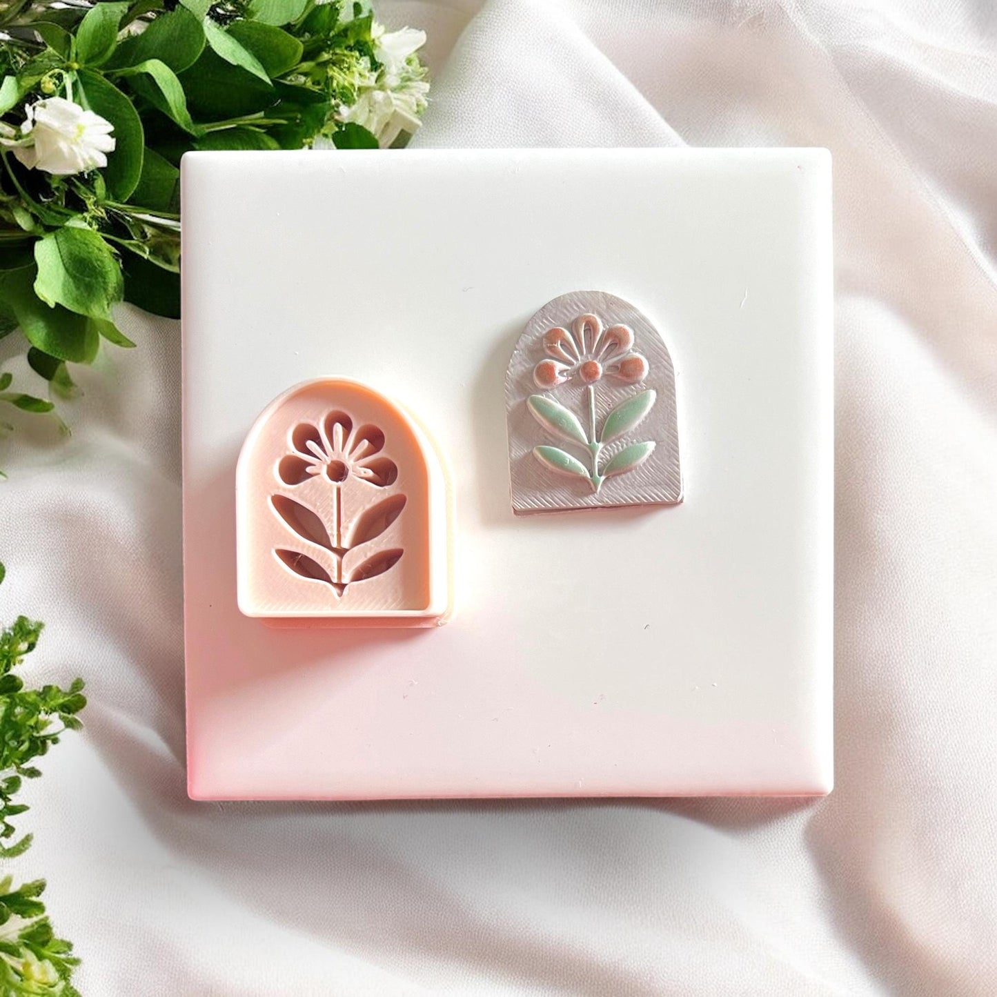 Peach flower arch cutter beside clay earring