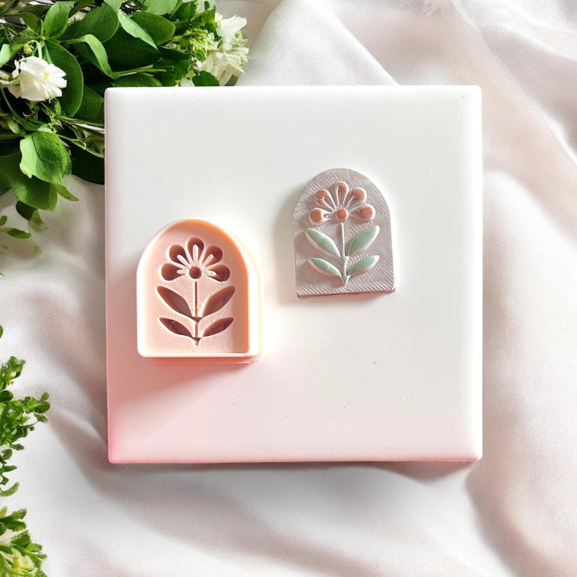 Peach flower arch cutter beside clay earring