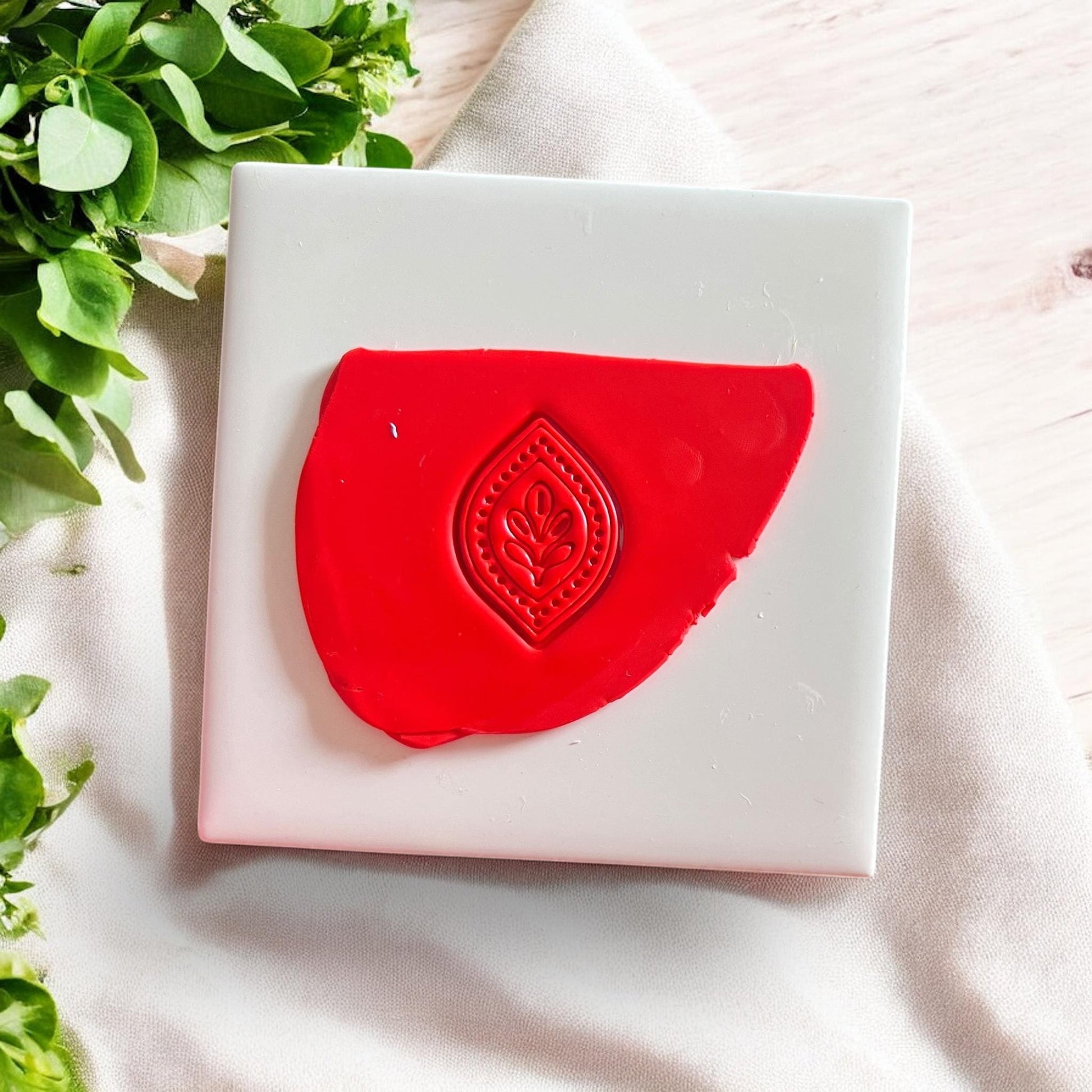 Clay imprint of folk-inspired leaf petal dangle design