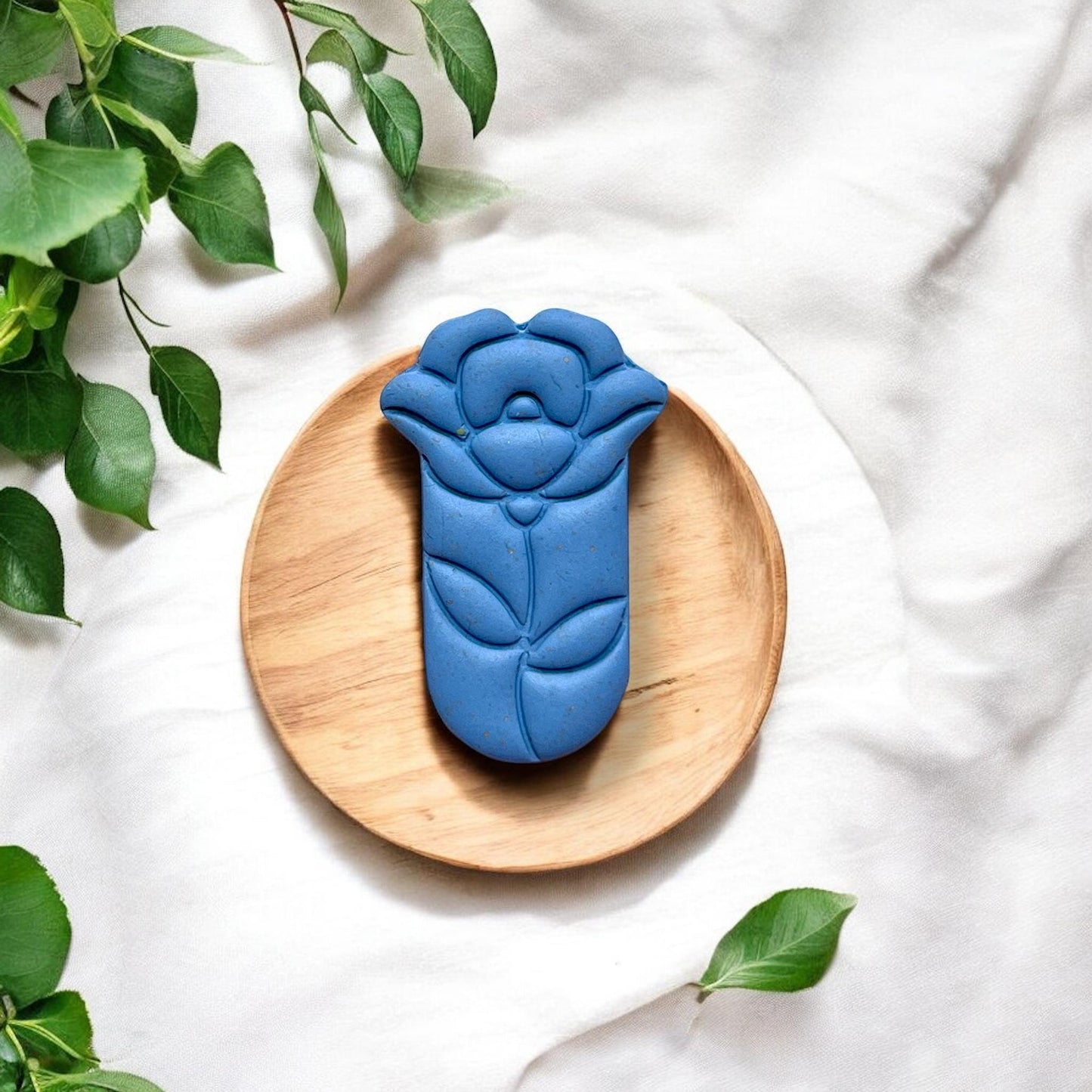 Finished blue teardrop flower clay piece on wood plate