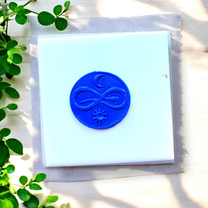 round blue clay pendant with celestial symbols