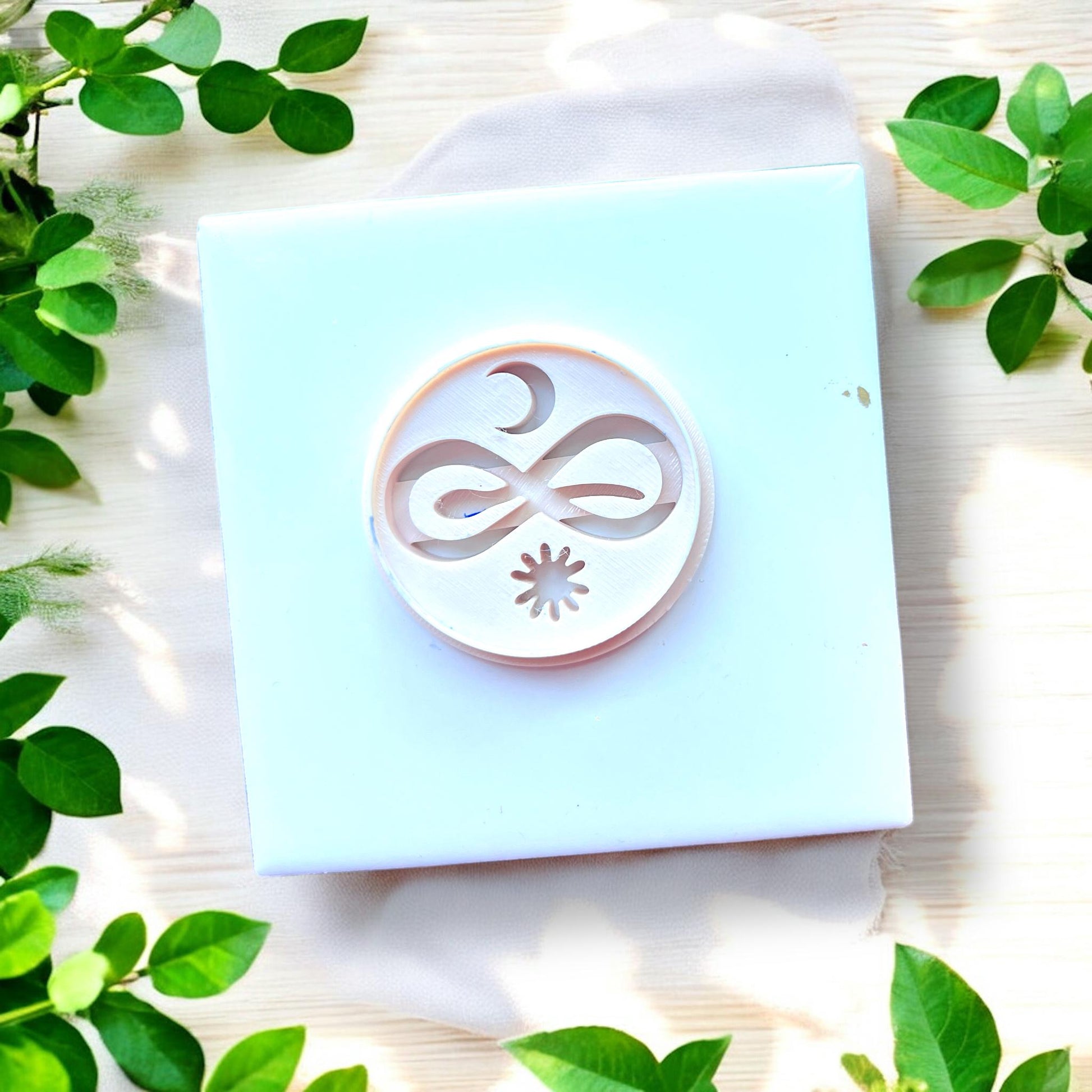 circular cutter with moon snake and sun design