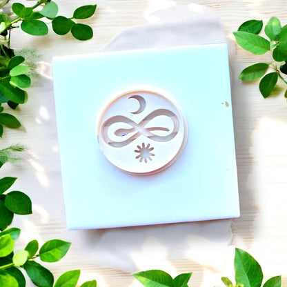 circular cutter with moon snake and sun design