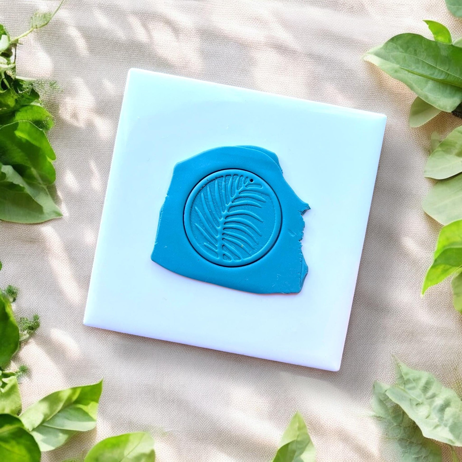 ound clay slab with palm leaf design