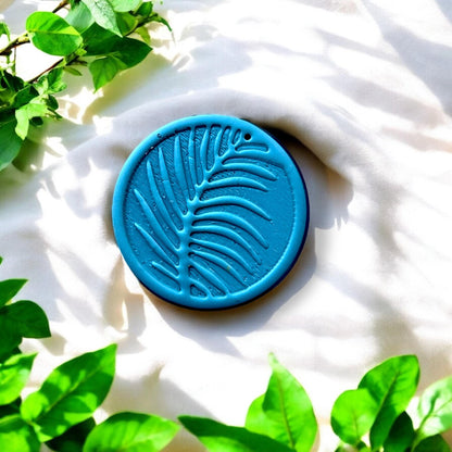 finished blue clay pendant with palm leaf