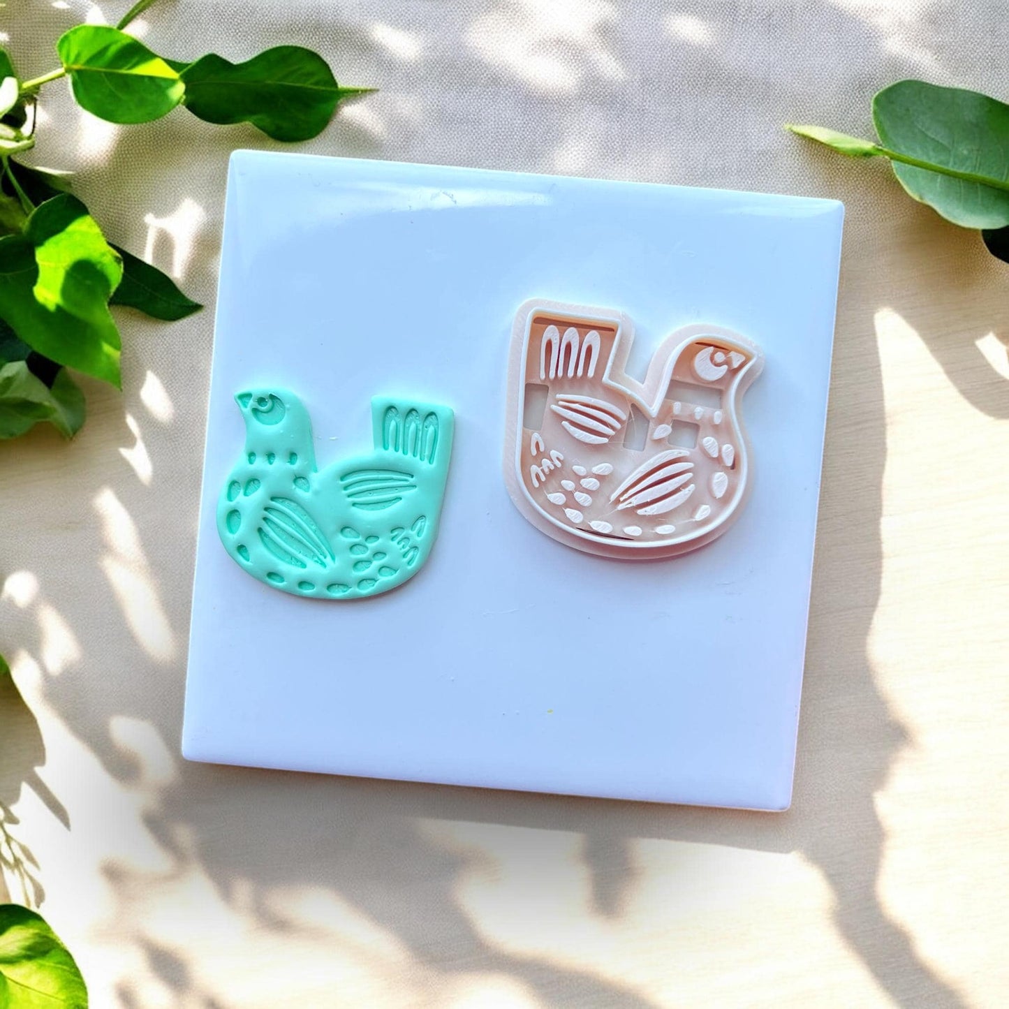 aqua bird clay charm next to white matching cutter