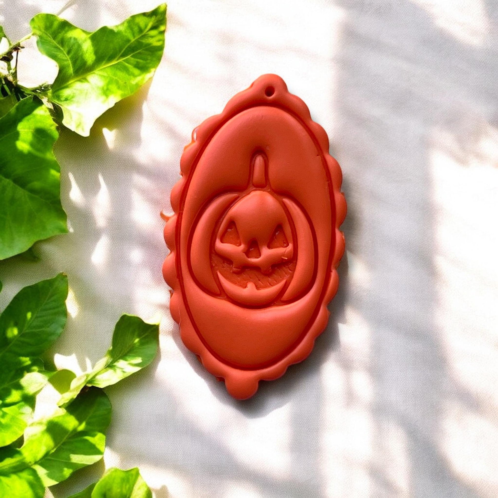 finished orange clay charm with scalloped frame