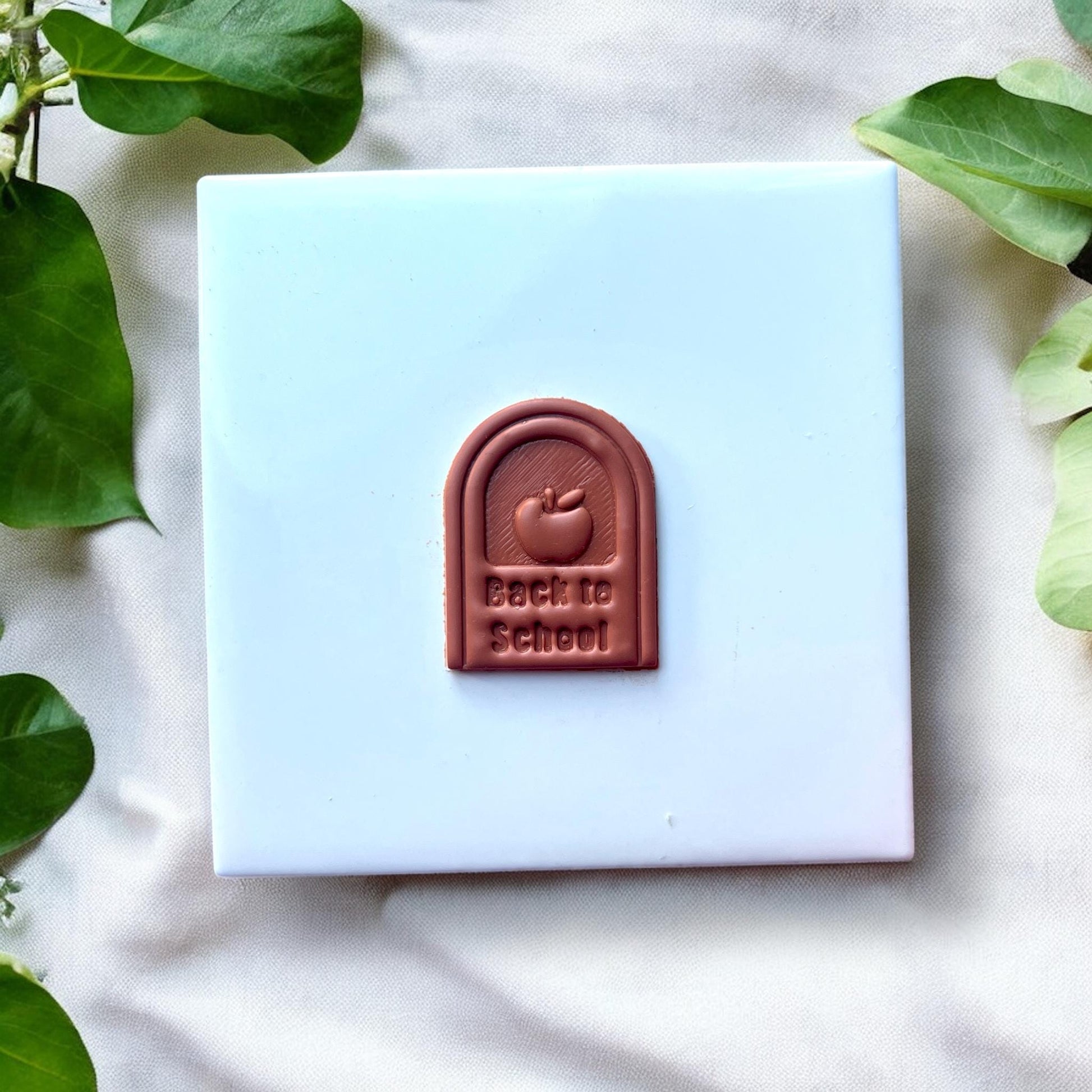 Cut and baked clay showing “Back to School” text and apple shape
