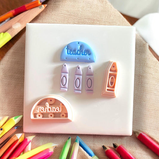 Polymer clay cutters next to finished pieces of arch and crayons