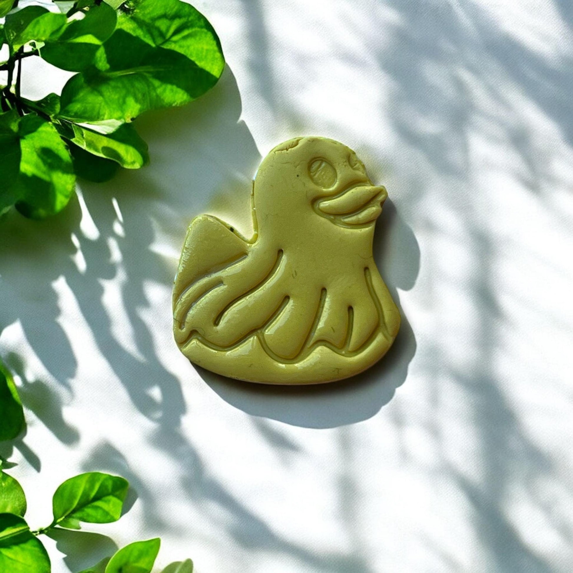 Finished duck floatie clay piece with leafy background