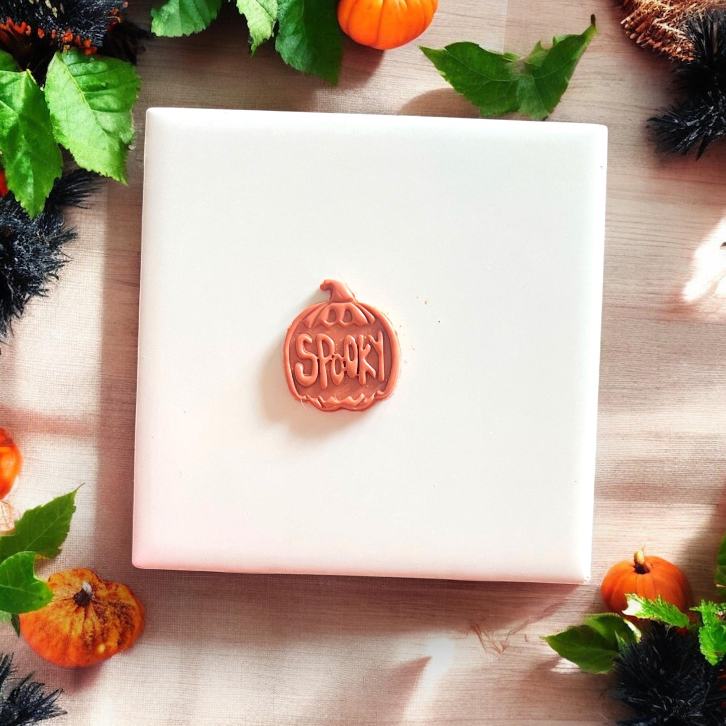 Single spooky pumpkin clay earring base on white tile