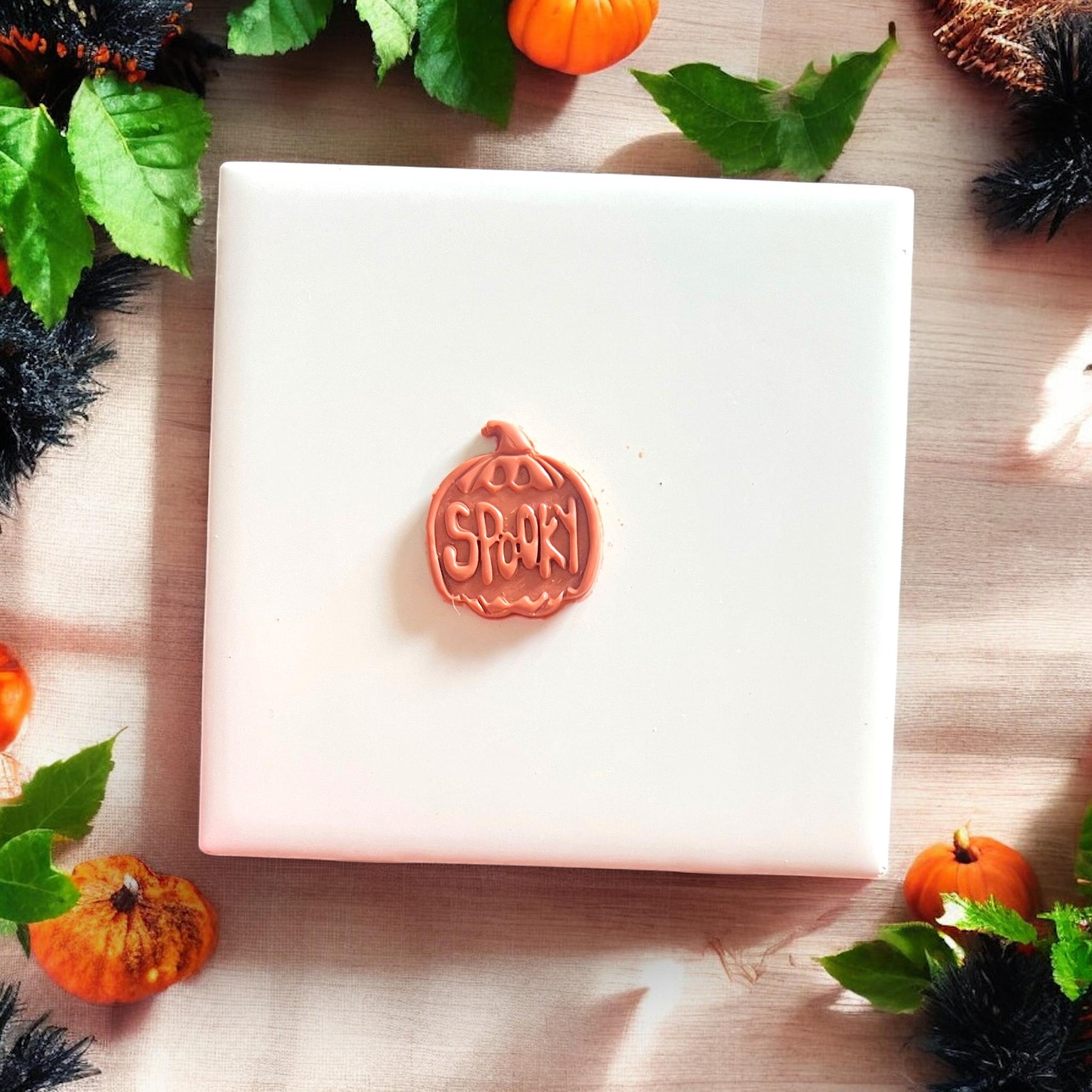 Single spooky pumpkin clay earring base on white tile