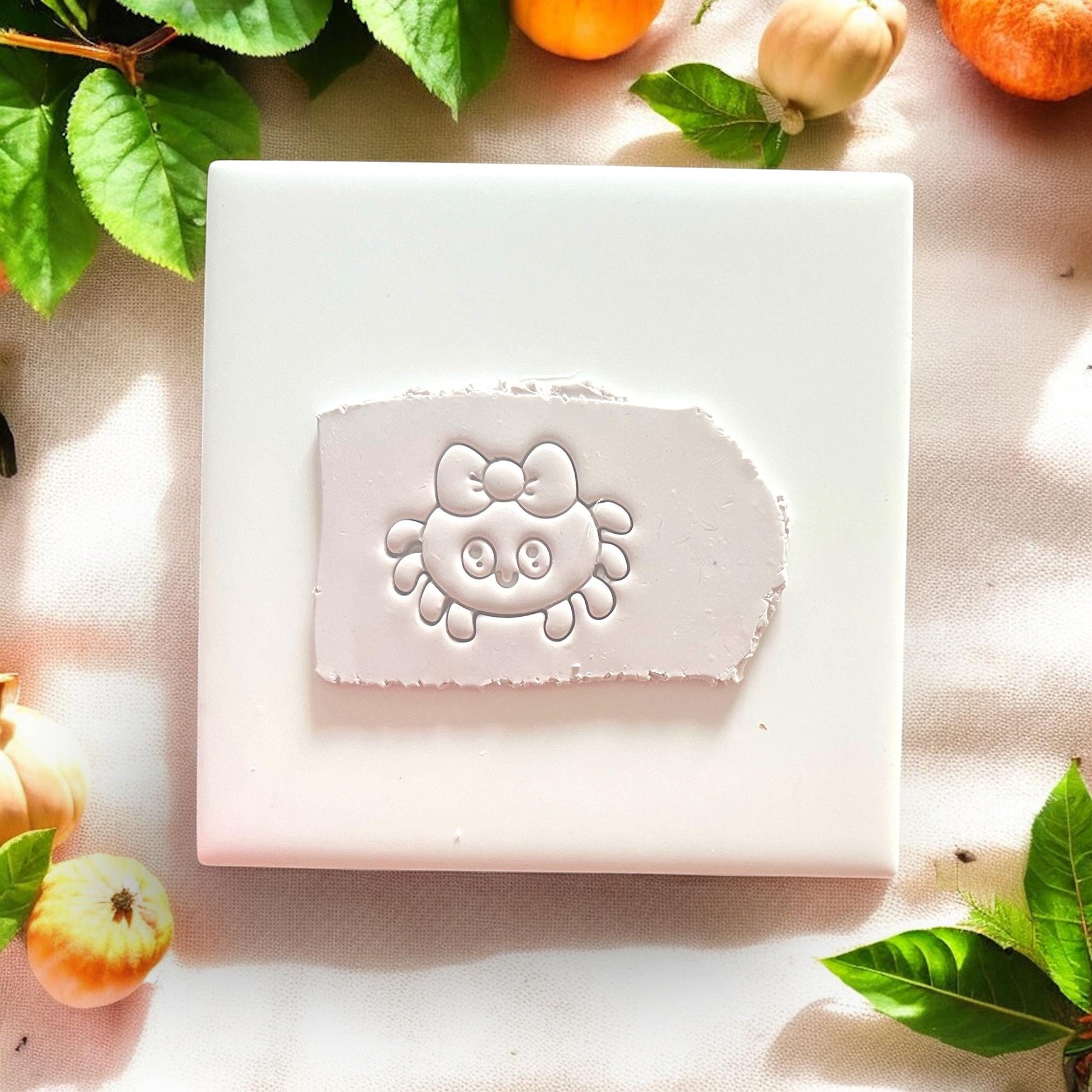 Cute spider clay cutter with bow impressed into white clay