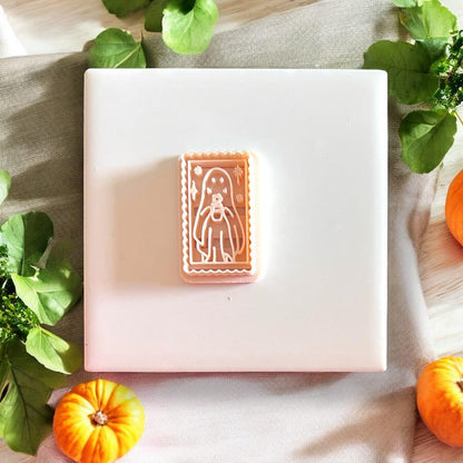 Clay impression of the ghost cameo stamp shown centered on a tile