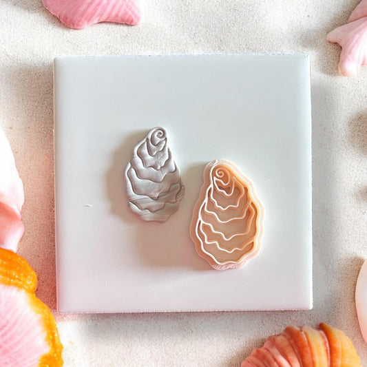 Polymer clay oyster earring sample in beach setting