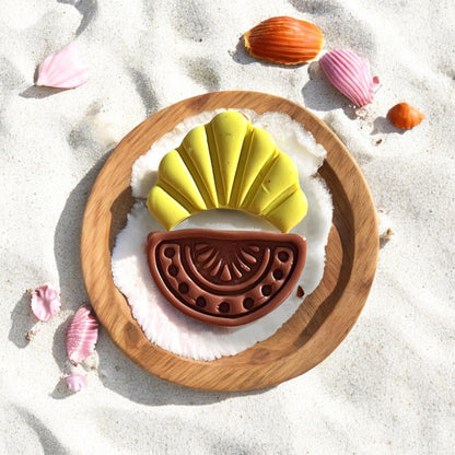 Clay earring styled on sand with seashells