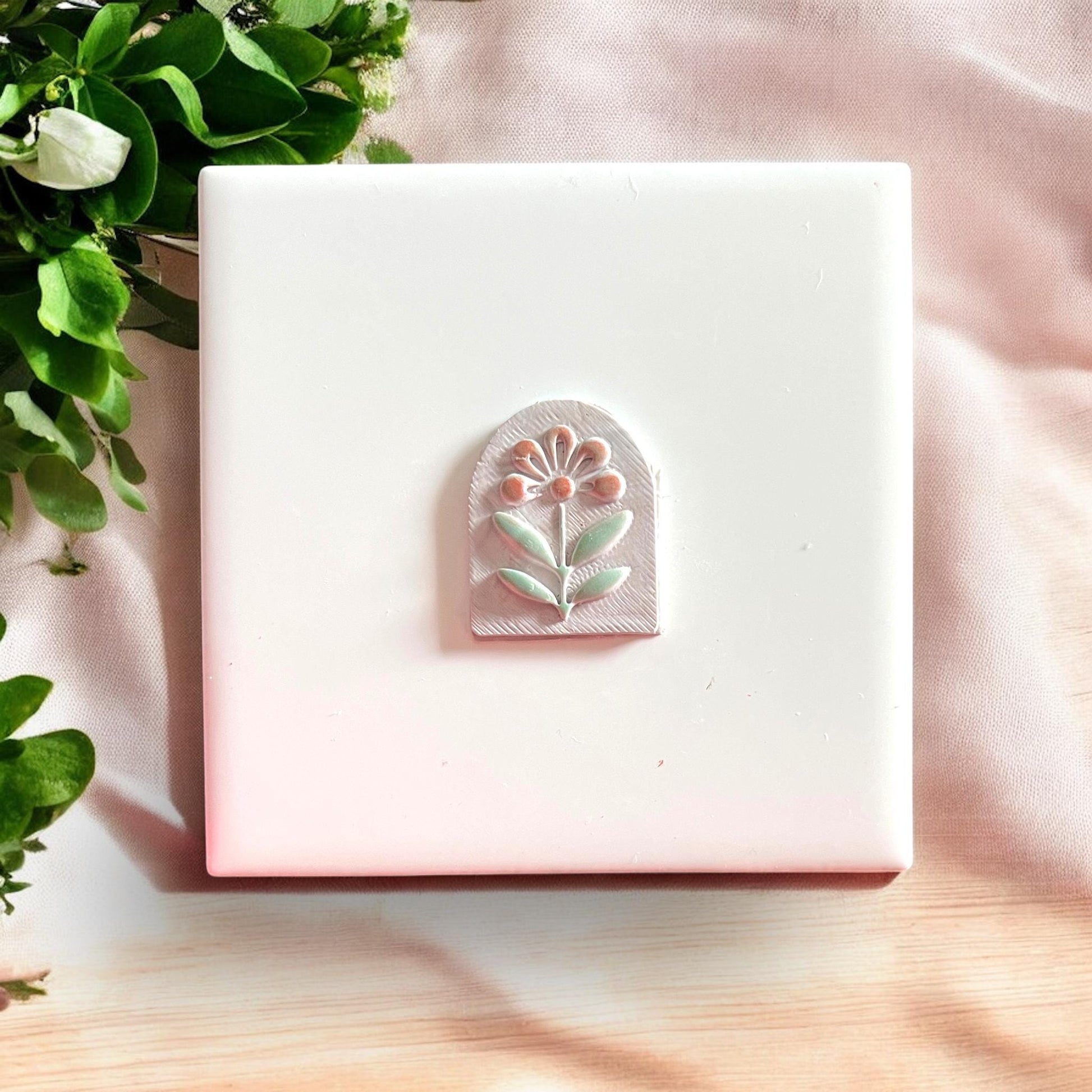 Polymer clay piece shaped like an arch with flower detail