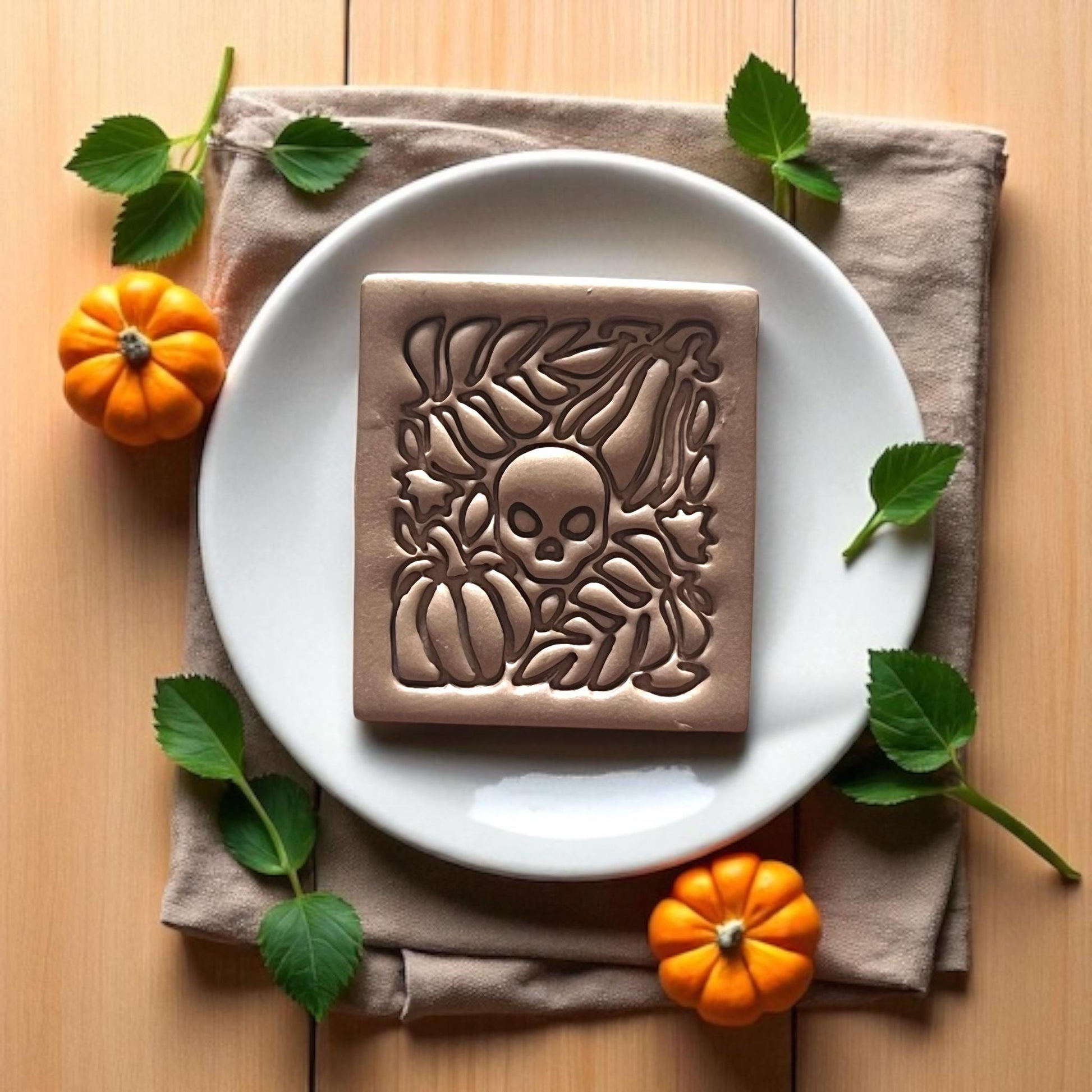 Small finished clay earring with skull and pumpkin detail