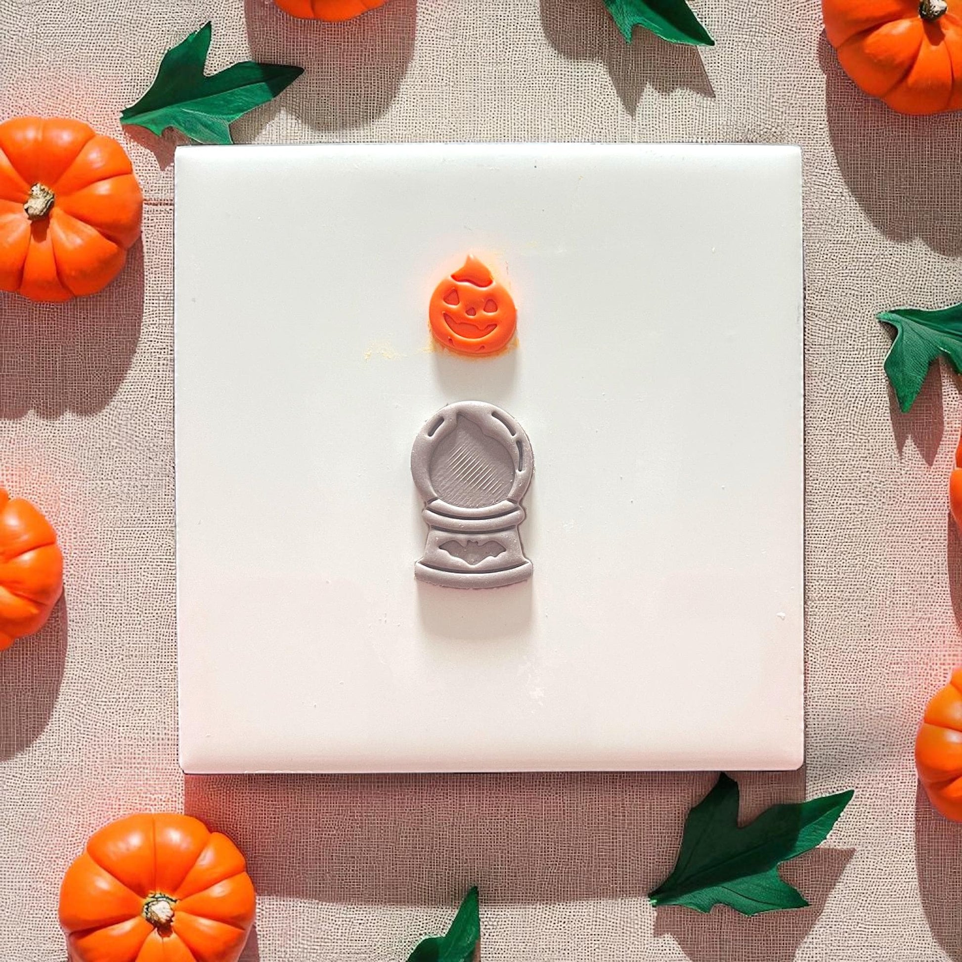 Finished pumpkin crystal ball clay piece on plate with pumpkins